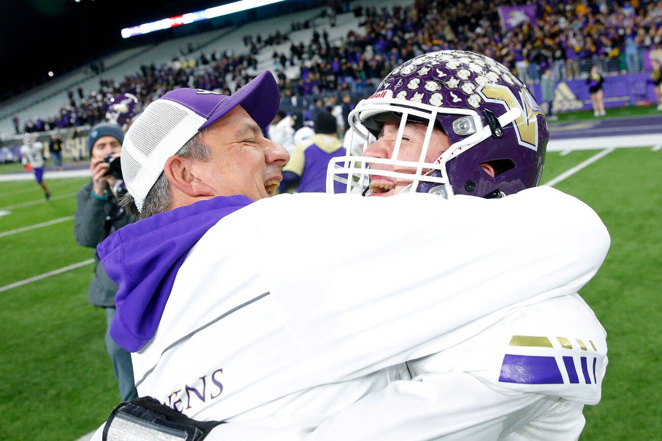 Lake Stevens head coach Tom Tri hugs quarterback Kolton Matson after the Vikings’ victory against Graham-Kapowsin in the WIAA 4A Football State Championship on Saturday, Dec. 2, 2023, at Husky Stadium in Seattle, Washington. (Ryan Berry / The Herald)