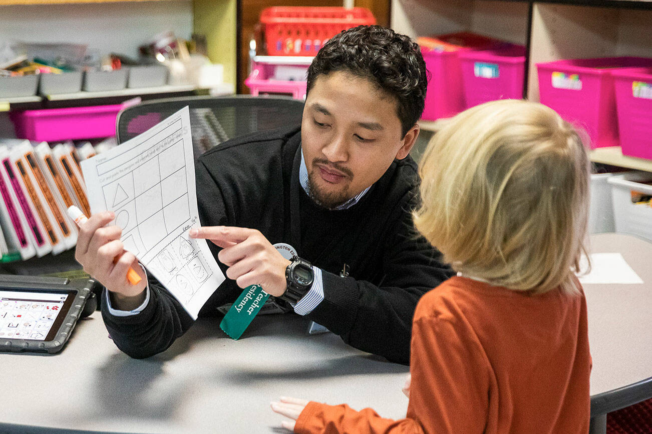 Picnic Point Elementary student teacher Joshua Wisnubroto goes through a worksheet with one of his students on Friday, Jan. 19, 2024 in Edmonds, Washington. (Olivia Vanni / The Herald)