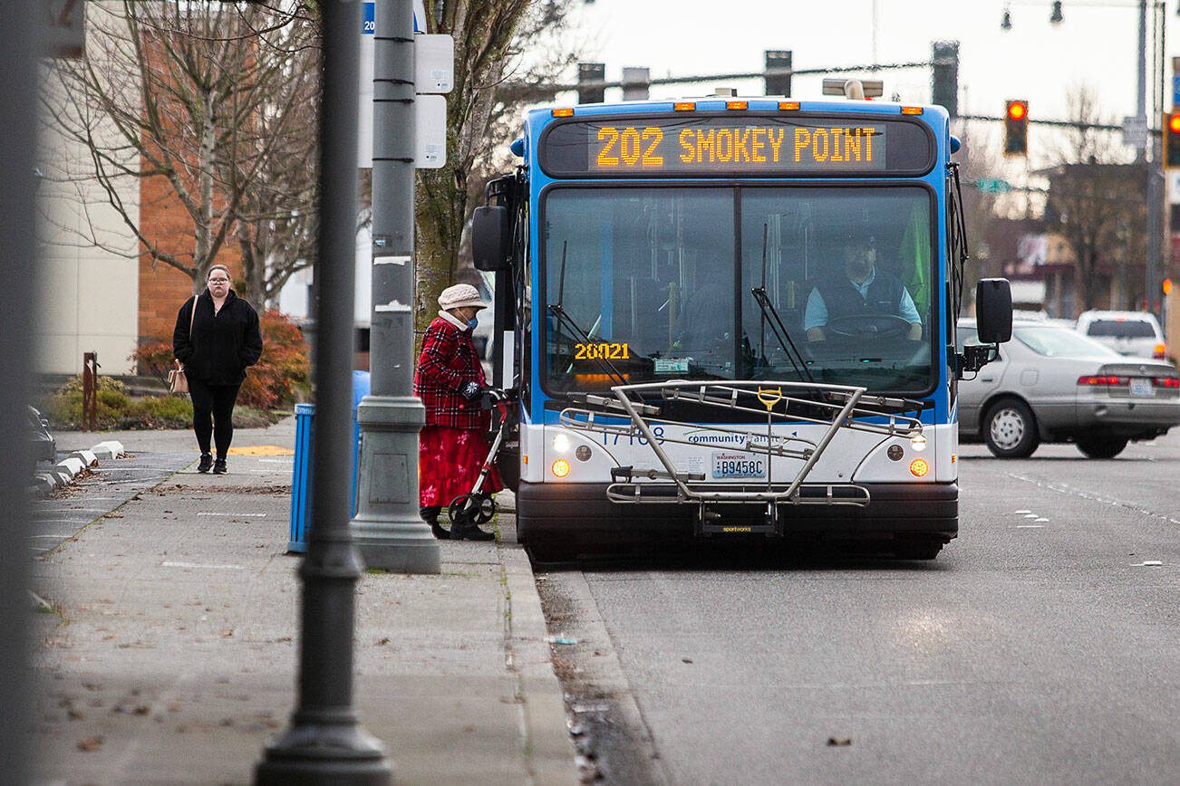 A transit rider steps onto a Community Transit bus on Tuesday, Jan. 3, 2023 in Everett, Washington. (Olivia Vanni / The Herald)