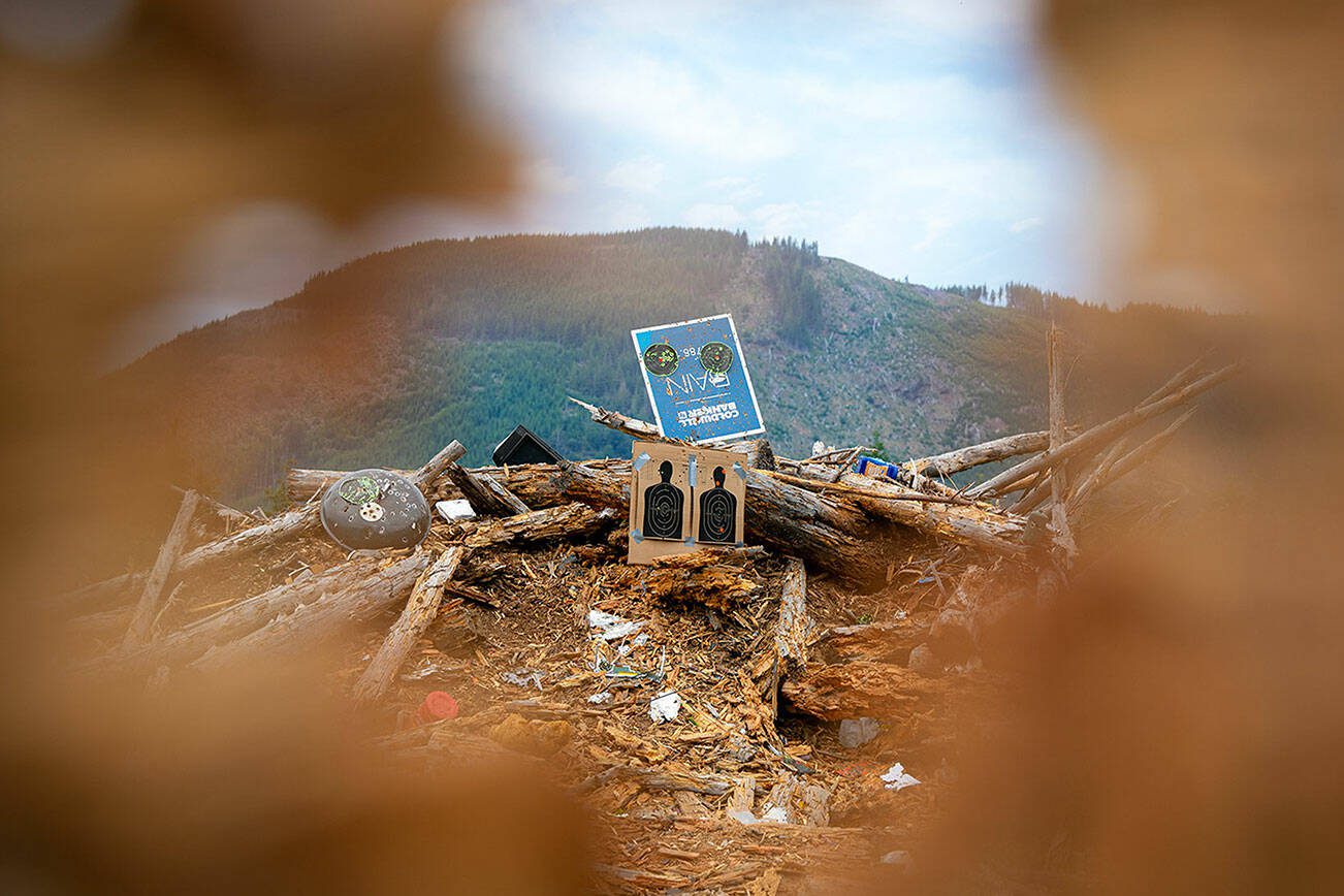 Targets and an assortment of trash and debris are mounded into a backstop at an unofficial shooting range along Green Mountain Road on Wednesday, July 17, 2024, near Granite Falls, Washington. Shell casings and trash are scattered along the road as well as throughout the clearcut area. (Ryan Berry / The Herald)