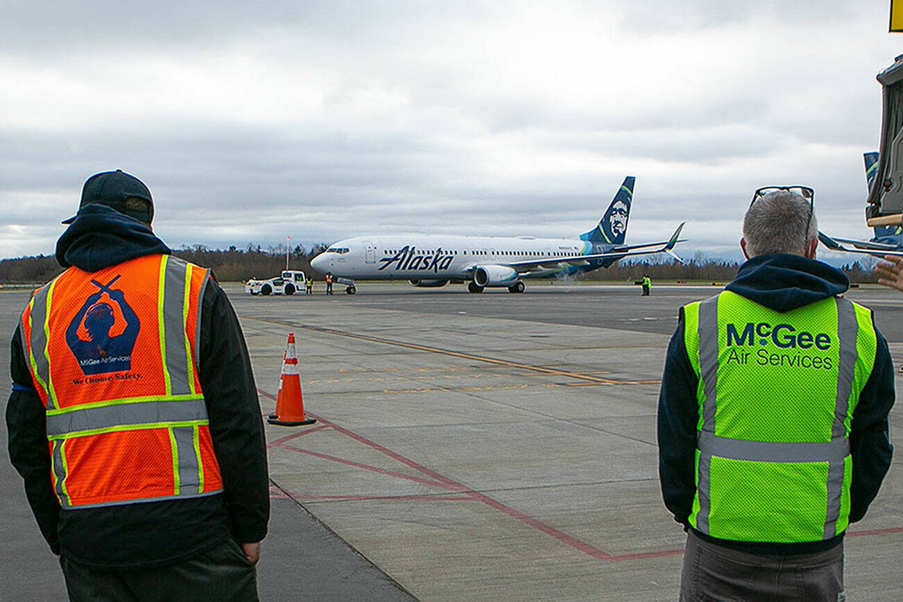 Ryan Berry / The Herald
Employees stand and watch the first Boeing 737 at Paine Field prepare to take off in 2022 in Everett.