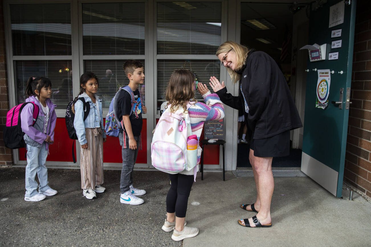 Second grade teacher Debbie Lindgren high-fives her students as they line up outside the classroom on the first day of school at Hazelwood Elementary on Wednesday, Sept. 4, 2024 in Lynnwood, Washington. (Olivia Vanni / The Herald)