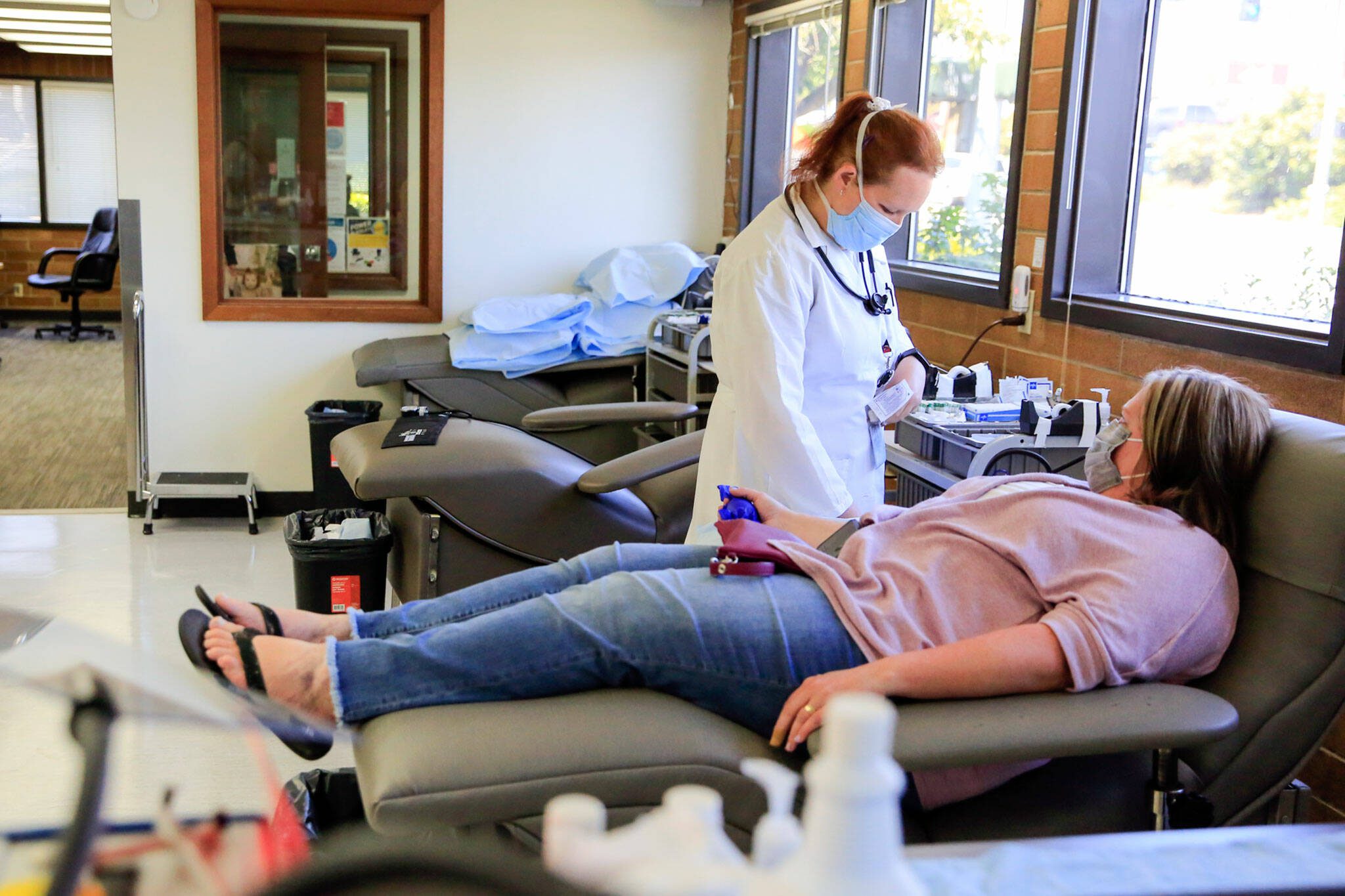 Kevin Clark / The Herald
Phlebotomist Heather Evans preps JaNeen Aagaard for a donation at Bloodworks NW in Everett in 2021.