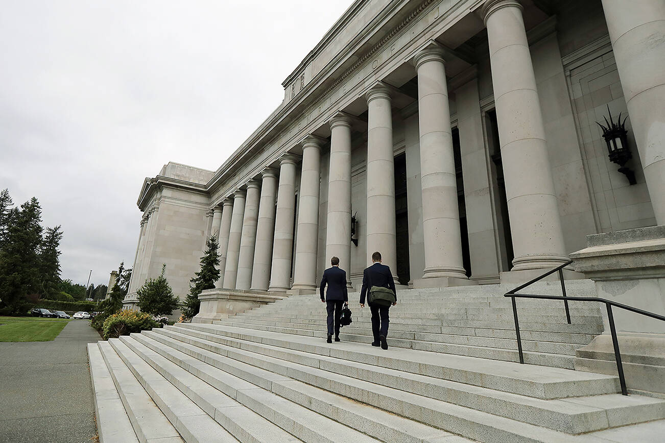 FILE - In this May 17, 2018, file photo attorneys walk up the steps of the Washington Supreme Court building, the Temple of Justice, in Olympia, Wash. The court on Thursday, Sept. 30, 2021, unanimously upheld the Washington's tax on big banks aimed at providing essential services and improving the state's regressive tax system. The 1.2% business and occupation surtax, a tax added on top of other taxes — was passed by the Legislature in 2019. (AP Photo/Ted S. Warren, File)