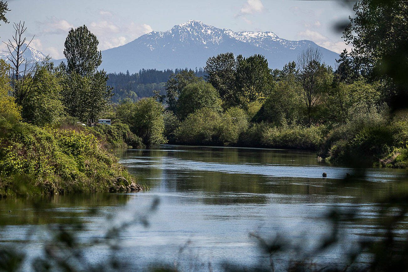 Snow is visible along the top of Mount Pilchuck from bank of the Snohomish River near Rotary Park on Wednesday, May 10, 2023 in Everett, Washington. (Olivia Vanni / The Herald)