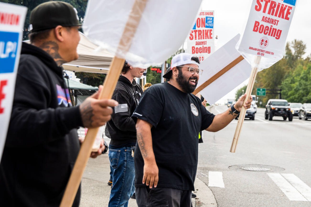 Matt Saldivar, a lead mechanic at Boeing for 5 years, smiles while picketing with other Boeing workers on strike on Monday, Sept. 16, 2024 in Everett, Washington. (Olivia Vanni / The Herald)