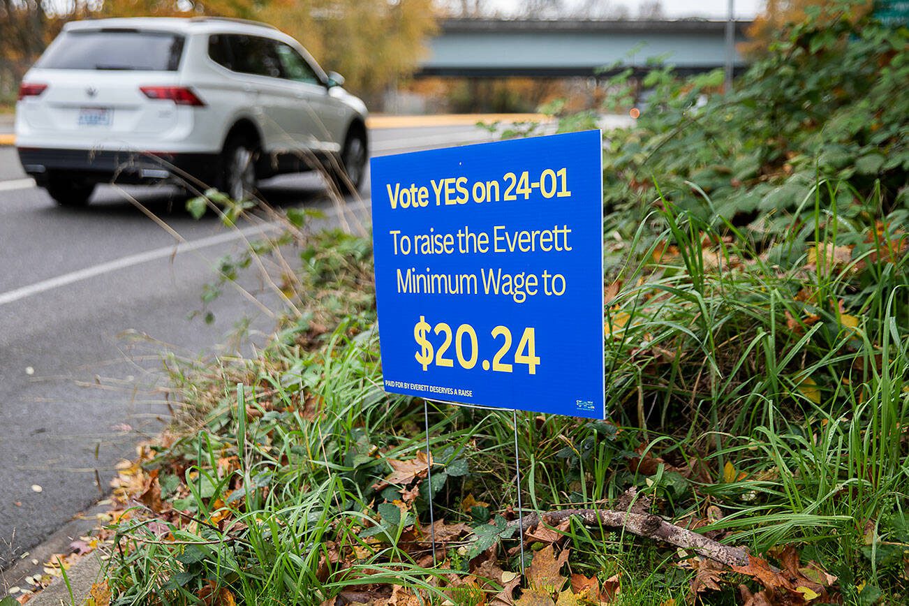 Cars getting onto an I-5 on-ramp drive past a sign encouraging people to vote “YES on 24-01” to raise the Everett minimum wage on Tuesday, Oct. 29, 2024 in Everett, Washington. (Olivia Vanni / The Herald)