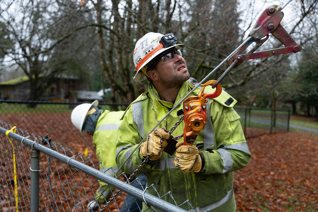 Brandon Hughes, a utility worker from Okanogan County, works on repairing a power line on Friday, Nov. 22 east of Lake Stevens, Washington. (Will Geschke / The Herald)