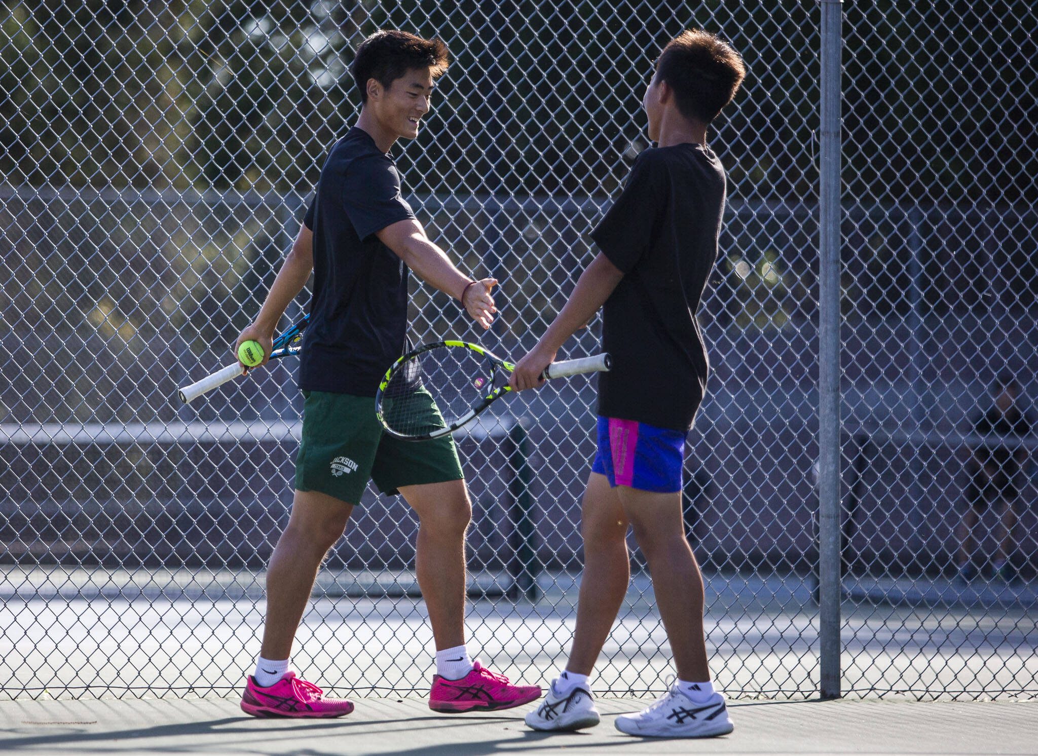 Jackson’s Ben Lee, left, high-fives teammate Samuel Song, right, during a match against Kamiak on Monday, Sept. 30, 2024 in Mill Creek, Washington. (Olivia Vanni / The Herald)