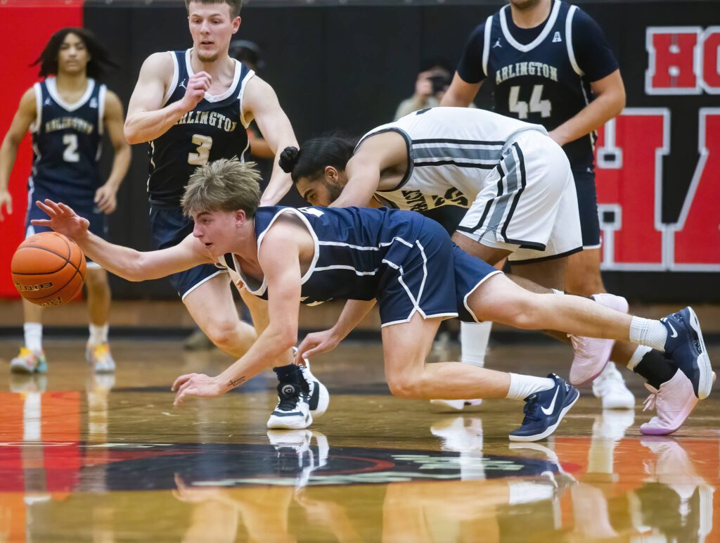 Arlington’s Leyton Martin lays out to try and grab a loose ball during the game against Mountlake Terrace on Tuesday, Dec. 10, 2024 in Mountlake Terrace, Washington. (Olivia Vanni / The Herald)
