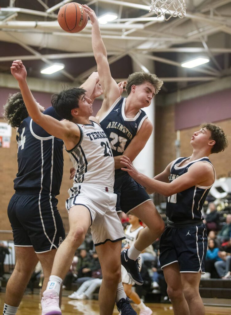 Mountlake Terrace and Arlington players all leap in the air for a rebound during the game on Tuesday, Dec. 10, 2024 in Mountlake Terrace, Washington. (Olivia Vanni / The Herald)
